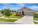 Well-kept property featuring an ample driveway, manicured lawn, and tasteful landscaping for an inviting appearance at 16341 Little Garden Dr, Wimauma, FL 33598
