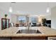 Open concept living area showcases a kitchen island with granite countertop and stainless steel sink at 16341 Little Garden Dr, Wimauma, FL 33598