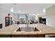 Open concept living area showcases a kitchen island with granite countertop and stainless steel sink at 16341 Little Garden Dr, Wimauma, FL 33598
