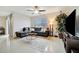 Bright living room offers ample seating, a decorative rug, and a modern ceiling fan at 16341 Little Garden Dr, Wimauma, FL 33598