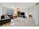 Light-filled living room with tile floors, a ceiling fan, and a comfortable sectional sofa at 16341 Little Garden Dr, Wimauma, FL 33598