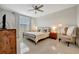 Relaxing main bedroom features a comfortable bed, stylish furnishings, and neutral decor at 16341 Little Garden Dr, Wimauma, FL 33598