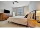 Spacious bedroom with a comfortable bed, dresser, and modern decor for relaxation at 16341 Little Garden Dr, Wimauma, FL 33598