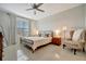 Bright bedroom includes a cozy bed, coordinating nightstands, and a comfortable armchair at 16341 Little Garden Dr, Wimauma, FL 33598