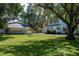 Large backyard with mature trees, garage, and room for outdoor activities at 1704 4Th W St, Palmetto, FL 34221