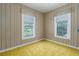 Cozy bedroom with wood paneled walls and natural light from two windows at 1704 4Th W St, Palmetto, FL 34221