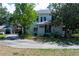 Inviting two-story home with a long driveway, lush landscaping, and a detached garage at 1704 4Th W St, Palmetto, FL 34221