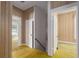 Hallway featuring a view of the bedroom and staircase with yellow carpet and wood paneling at 1704 4Th W St, Palmetto, FL 34221