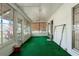 Inviting sunroom with green carpet, wood-paneled walls and ceiling fan at 1704 4Th W St, Palmetto, FL 34221