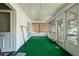 Enclosed porch with green carpet, white walls, and lots of windows at 1704 4Th W St, Palmetto, FL 34221