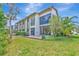 Expansive backyard view of two-story home with a brick patio, surrounded by lush greenery at 1712 Starling Dr # 101, Sarasota, FL 34231
