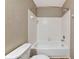 Cozy bathroom offering a white tub and shower featuring white wall tile, a shower rod, and a white toilet at 1712 Starling Dr # 101, Sarasota, FL 34231
