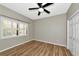 Light-filled bedroom features wood-look floors, a ceiling fan, and a large window with plantation shutters at 1712 Starling Dr # 101, Sarasota, FL 34231