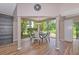 Sunlit dining area with large windows offering lush landscape views and stylish chandelier at 1712 Starling Dr # 101, Sarasota, FL 34231