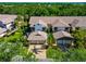 Charming townhome featuring a brick driveway, two-car garage, and lush landscaping surrounded by mature trees at 1712 Starling Dr # 101, Sarasota, FL 34231