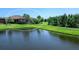 A serene backyard view of a pond with lush landscaping and a screened lanai at 17820 Waterville Pl, Lakewood Ranch, FL 34202