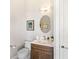 Charming half bathroom with a unique oval mirror, elegant fixtures, and a marble countertop at 17820 Waterville Pl, Lakewood Ranch, FL 34202