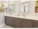 Bathroom featuring double sinks with cabinets and decorative mirrors at 17820 Waterville Pl, Lakewood Ranch, FL 34202