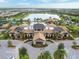 A large clubhouse featuring a porte-cochere, lush landscaping, and a lake view at 17820 Waterville Pl, Lakewood Ranch, FL 34202