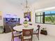 Bright dining room featuring a round table, an aquarium and a statement chandelier at 17820 Waterville Pl, Lakewood Ranch, FL 34202