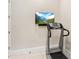 Modern exercise room featuring a treadmill and a TV mounted on the wall at 17820 Waterville Pl, Lakewood Ranch, FL 34202