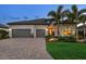 Beautiful exterior featuring a brick driveway, a two-car garage, stone accents and professionally landscaped yard at 17820 Waterville Pl, Lakewood Ranch, FL 34202