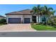 Beautiful exterior featuring a brick driveway, a two-car garage, stone accents and professionally landscaped yard at 17820 Waterville Pl, Lakewood Ranch, FL 34202