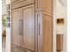 Custom wood refrigerator seamlessly blends with cabinetry, complemented by custom hardware and design at 17820 Waterville Pl, Lakewood Ranch, FL 34202