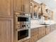 Modern kitchen with stainless steel double oven, custom cabinets and drawers, and marble backsplash at 17820 Waterville Pl, Lakewood Ranch, FL 34202