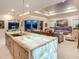 Bright, open-concept kitchen with island, flowing into living area with fireplace and sliding doors to backyard at 17820 Waterville Pl, Lakewood Ranch, FL 34202