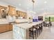 Well-lit kitchen with large island, pendant lighting, and stainless appliances with adjacent dining area at 17820 Waterville Pl, Lakewood Ranch, FL 34202