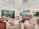 Spacious living room with ample seating, fireplace, and sliding glass doors leading to a screened lanai at 17820 Waterville Pl, Lakewood Ranch, FL 34202