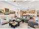 Airy living room with a large sectional, accent chairs, and curated art leading into the kitchen at 17820 Waterville Pl, Lakewood Ranch, FL 34202
