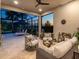 Inviting outdoor living area with comfortable seating, a ceiling fan, and views of the pool and landscape at 17820 Waterville Pl, Lakewood Ranch, FL 34202