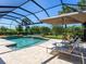 Inviting pool area with comfortable lounge chairs, an umbrella, and views of the beautiful landscape at 17820 Waterville Pl, Lakewood Ranch, FL 34202