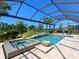 Stunning screened-in pool area complete with water features, a hot tub, and lush landscaping for ultimate relaxation at 17820 Waterville Pl, Lakewood Ranch, FL 34202