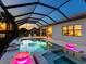 Inviting screened pool and spa area with landscape lighting and an outdoor dining space at 17820 Waterville Pl, Lakewood Ranch, FL 34202