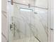 Modern shower featuring seamless glass enclosure and marble tiling at 17820 Waterville Pl, Lakewood Ranch, FL 34202