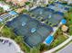 Aerial view of the community's multiple tennis courts with covered seating areas and pristine landscaping at 17820 Waterville Pl, Lakewood Ranch, FL 34202