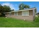 A spacious backyard with lush green lawn and gray house in background at 1813 5Th W St, Palmetto, FL 34221