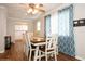 Light-filled dining room with a stylish table, a view into the kitchen, and patterned curtains at 1813 5Th W St, Palmetto, FL 34221