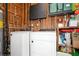 Functional laundry area featuring a washer and dryer with wood paneling and ample storage shelves at 1813 5Th W St, Palmetto, FL 34221