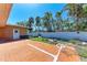 Backyard space with faux grass and a light stucco building featuring a white door at 216 Archer Way, Anna Maria, FL 34216