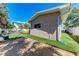 Turfed backyard bordered by landscaping on the side of a light stucco building at 216 Archer Way, Anna Maria, FL 34216