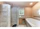 Bathroom featuring a tiled shower, jetted tub, single vanity, and a window providing natural light at 216 Archer Way, Anna Maria, FL 34216