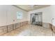 Bedroom during renovation with a window, closet, and neutral tile flooring creating a bright blank canvas at 216 Archer Way, Anna Maria, FL 34216