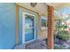 Inviting entryway with a blue-painted doorframe, brick column, and quaint curb appeal at 216 Archer Way, Anna Maria, FL 34216