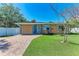 Charming single-story home with a brick driveway, lush green lawn, and well-maintained landscaping at 216 Archer Way, Anna Maria, FL 34216