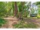View of the spacious backyard featuring mature trees and an outdoor structure, perfect for gardening at 2326 2Nd E Ave, Bradenton, FL 34208