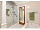 Well-lit bathroom featuring a glass-enclosed shower, soaking tub, tiled walls and neutral decor for a serene experience at 2326 2Nd E Ave, Bradenton, FL 34208